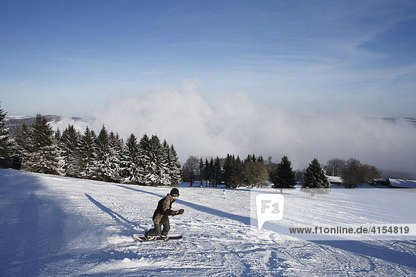 Snowboarder on a ski-run  Mt. Kreuzberg near Bischofsheim  Rhoen Mountains  Lower Franconia  Bavaria  Germany  Europe