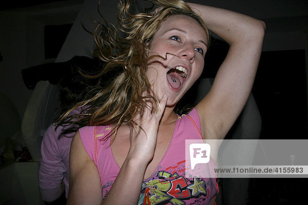 Young woman dancing wildly at a party