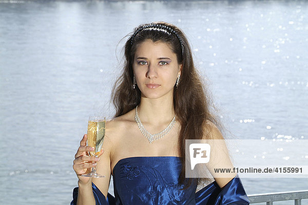 Young woman in festive evening clothes with champagne glass in her hand