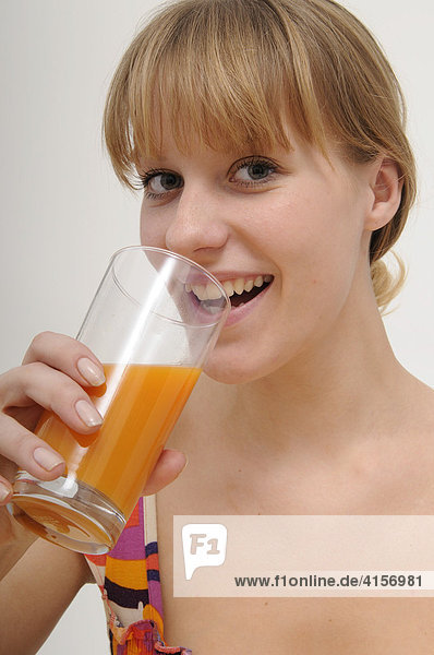 Blonde Frau trinkt Orangensaft