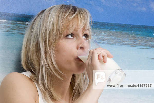 Blonde Frau in Unterwäsche trinkt ein Glas Milch Fototapete