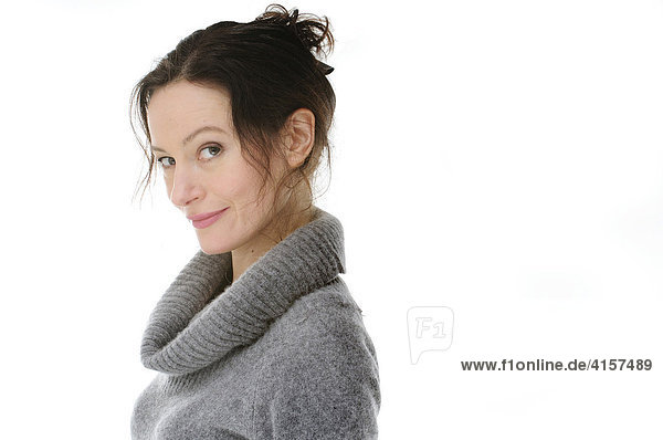 Woman wearing grey sweater smiling mischievously (cutout)