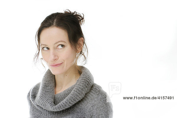 Frau mit grauem Pullover lächelt und schaut verschmitzt (Freisteller)