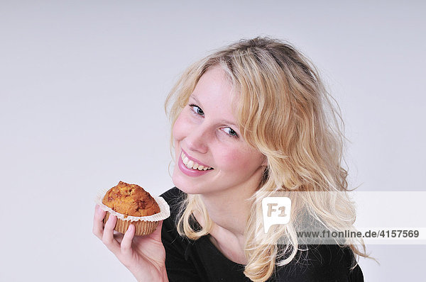Blonde Frau isst Muffin