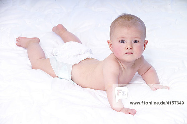 5 Monate altes Baby stützt sich ab auf weißer Decke