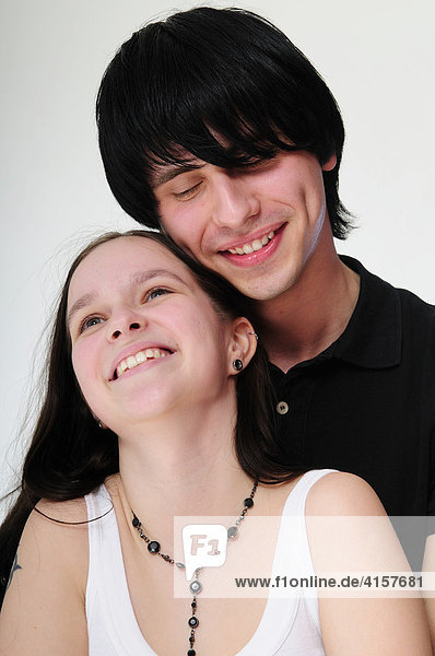 Portrait of a young  smiling black-haired couple embracing