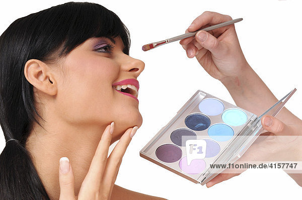 Pretty black-haired woman with a fringe  being made-up  make-up  beauty  pink  purple  lipstick  eyeshadow  colours