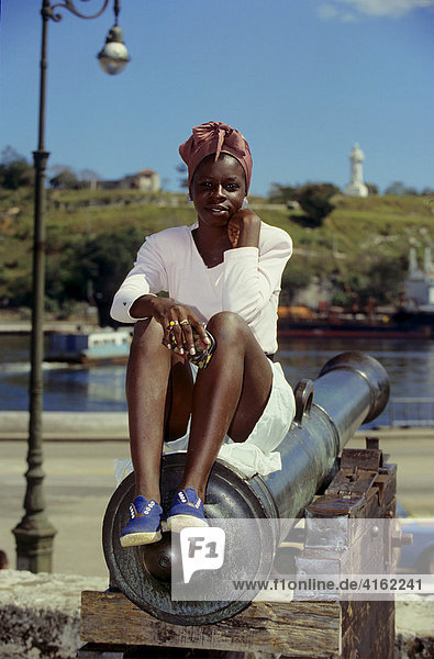 Nationalmuseum in der Altstadt von Havanna. Junge farbige Frau sitzt auf einer Kanone.  Havanna  KUBA