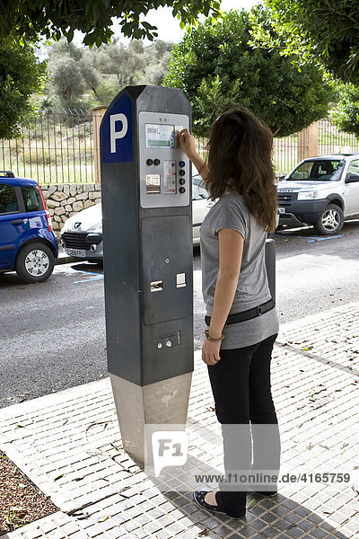 Junge Frau löst ein Parkticket an einem Parkscheinautomat in Eivissa  Ibiza  Balearen  Spanien