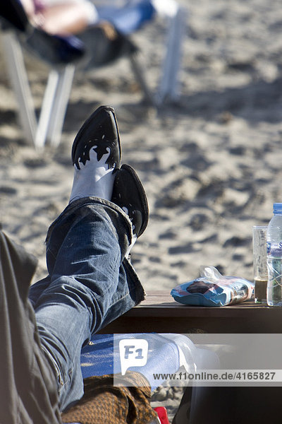 Man with Cowboy boots at Les Salinas beach  Ibiza  Balearen  Spanien