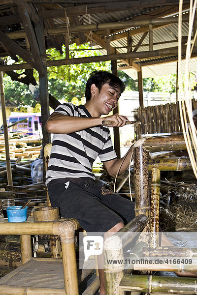 Arbeiter zimmert einen Bambusstuhl aus Bambus in einer Fabrik für Bambusmöbel  Insel Lombok  Kleine Sunda-Inseln  Indonesien