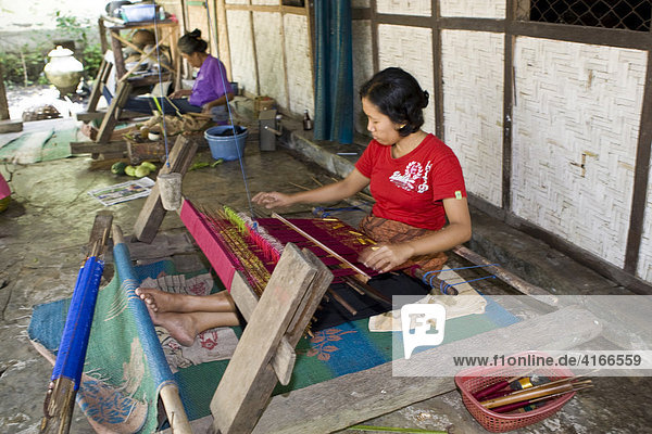 Frau webt in traditioneller Weise Stoffe an einem alten Webstuhl  Tete Batu  Insel Lombok  Kleine-Sunda-Inseln  Indonesien