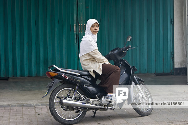 Junge Muslima stitzt auf einem Moped  Mataram  Insel Lombok  Kleine-Sunda-Inseln  Indonesien
