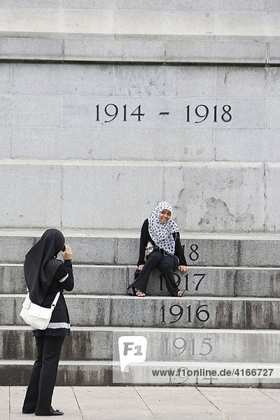 Zwei Muslima fotografieren sich vor dem Memorial Denkmal an der St. Andrew's Road  Singapur  Südostasien  Asia