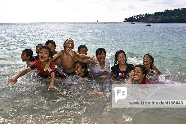 Children playing happily in the sea  Lombok Island  Lesser Sunda Islands  Indonesia  Asia