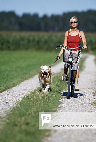 Radfahrerin mit Hund  Starnberg  Bayern  Deutschland