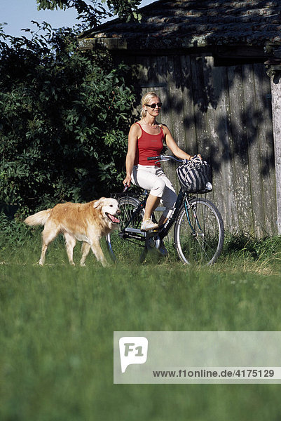 Radfahrerin mit Hund  Starnberg  Bayern  Deutschland