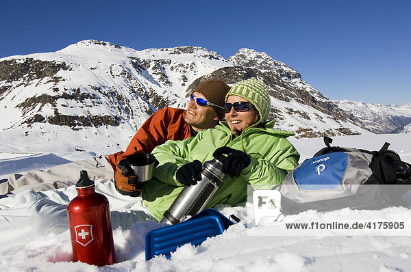Junges Paar macht Rast im Schnee  Bieler Höhe  Galtür  Tirol  Österreich