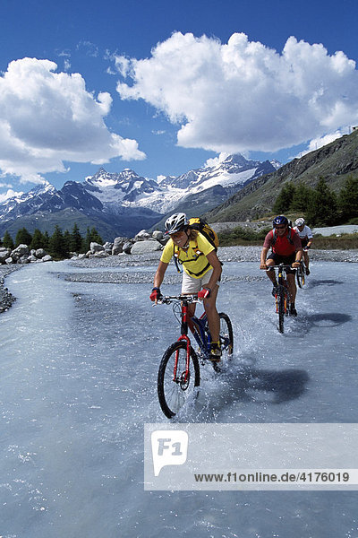 Mountain bikers  Grinjisee Lake  Mt. Zinalrothorn  Zermatt  Valais  Switzerland  Europe