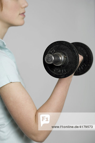 Young woman exercising with a dumbbell