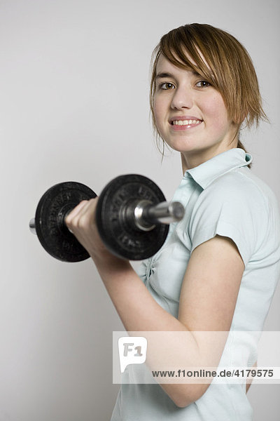 Young woman exercising with a dumbbell