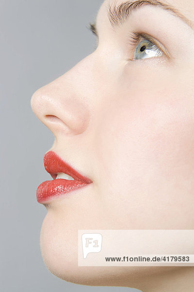 Close-up of young woman's face  profile  red lips mouth