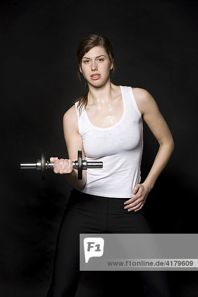Young woman working out with weights  barbells