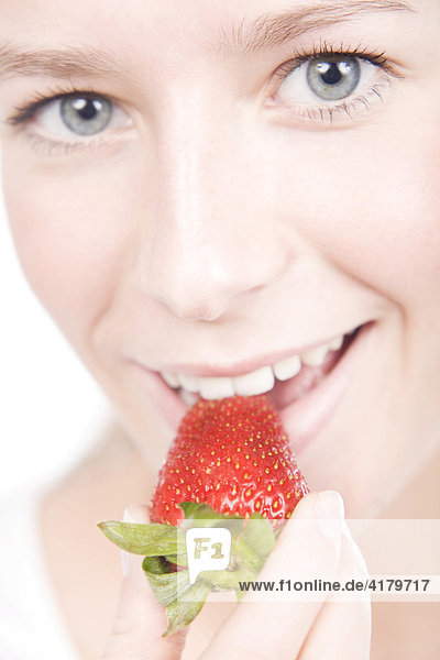 Junge Frau ißt eine Erdbeere