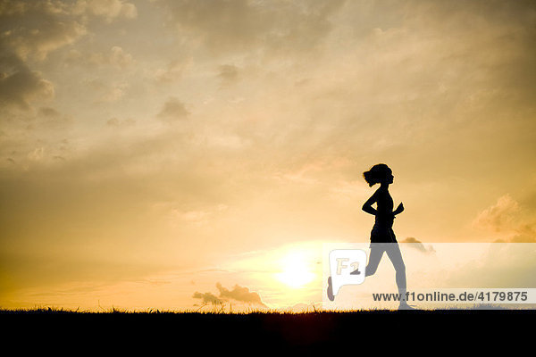 Silhouette einer Läuferin vor Sonnenuntergang