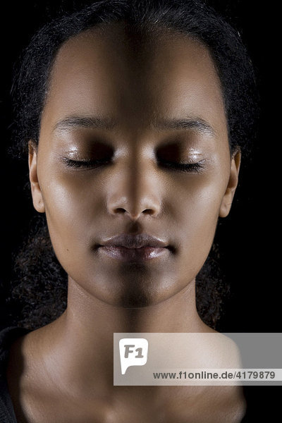 Portrait of a young dark-skinned woman with closed eyes
