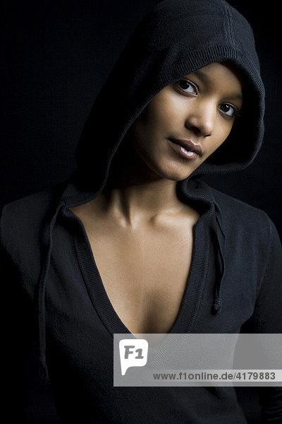 Dark-skinned  hooded woman  looking into the camera