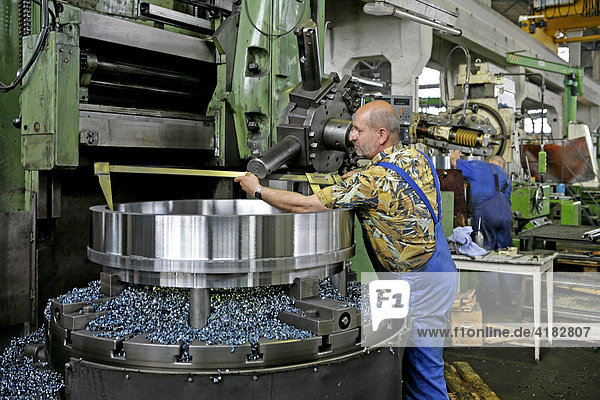 Metal processing factory  a turned flange is being measured