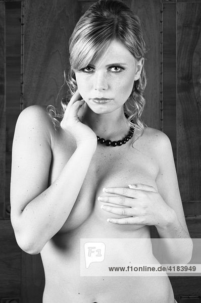 Junge Frau in erotischer Pose in einer Hotelsuite vor altem Kasten  schwarzweiß