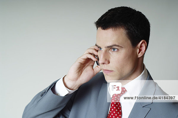 Young businessman making a call with his mobile phone (cellphone)