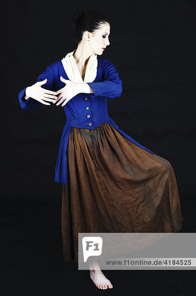 Junge Balletttänzerin in altem Kostüm in Tanzpose