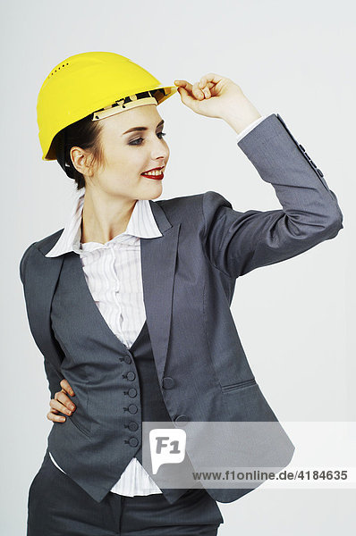 Geschäftsfrau mit gelbem Helm  lächelnd