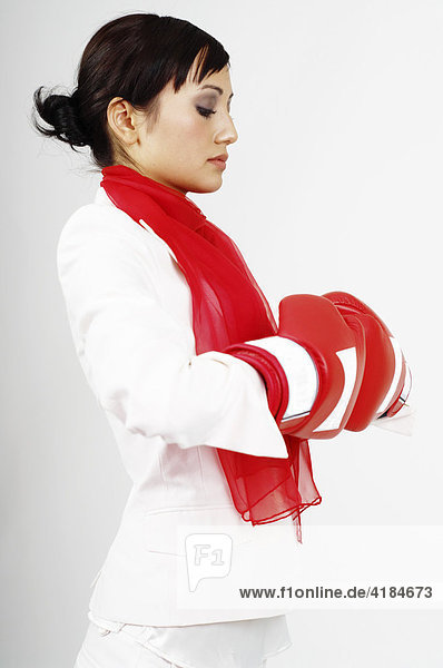 Junge Geschäftsfrau  Managerin  Business Frau mit roten Boxhandschuhen
