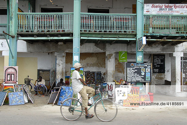 Straßenszene  Radfahrer fährt vor altem Haus vorbei  Stone Town  Sansibar  Tansania  Afrika