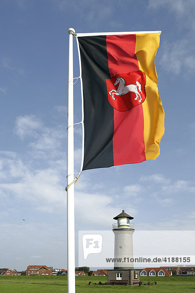 Deutschlandflagge mit Wappen von Niedersachsen vor Leuchtturm  Insel Juist  Deutschland