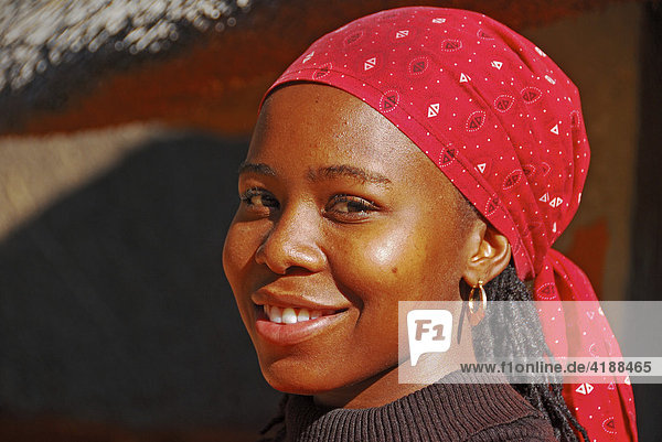 Portrait-dunkelhäutige Frau mit rotem Kopftuch lächelt in die Kamera Südafrika  Afrika