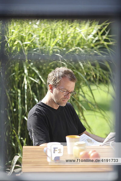 Lesender Mann im Garten