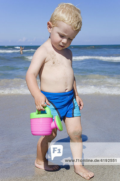Ein kleiner Junge spielt am Strand von Can Picafort  Mallorca