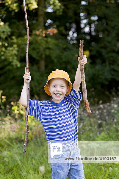Ein Junge  vier Jahre alt  sammelt im Wald Stöcke