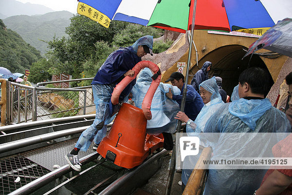 Chinesische Touristen auf dem Weg zur Chinesischen Mauer mit einer Bahn  Regen  Peking  Beijing  China