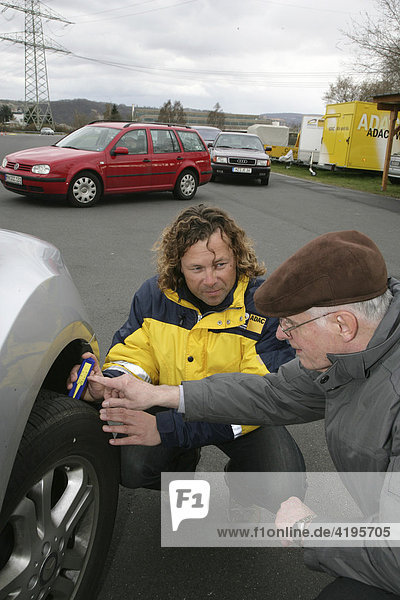 Dirk Mueller  ADAC (German automobile club) instructor explaining the importance of the correct tire tread depth and air pressure to a participant in the senior’s safety training at the practice area in Koblenz  Germany  25.03.2008