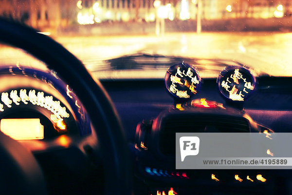 Unscharfe Sicht auf das beleuchtete Armaturenbrett eines Wagens bei Nacht
