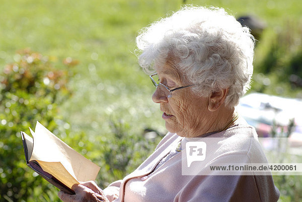 Seniorin beim Lesen in einem alten Tagebuch