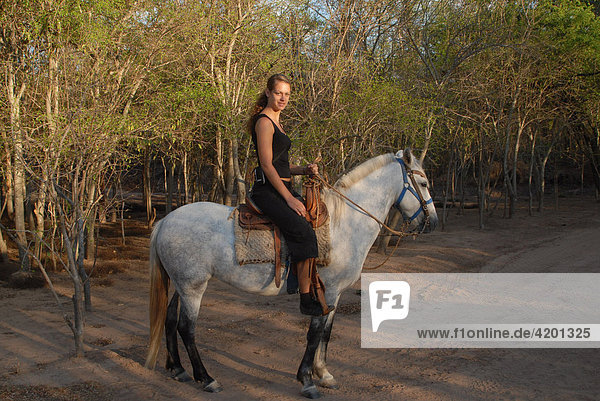 Young woman on a white horse before riding through the farm  Gran Chaco  Paraguay