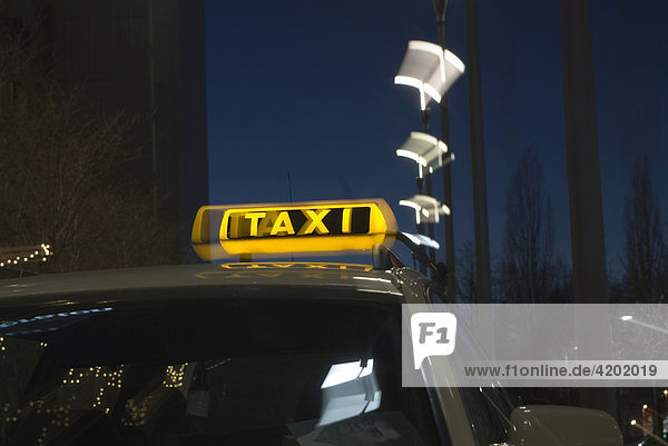 Erleuchtetes Taxischild in der Dämmerung München Bayern Deutschland
