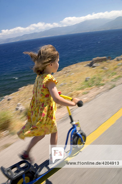 Kind fährt Roller an der Küste  Peloponnes  Griechenland